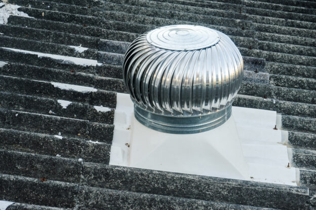 exaustor eólico instalado em telhado comercial promovendo ventilação natural e sustentável