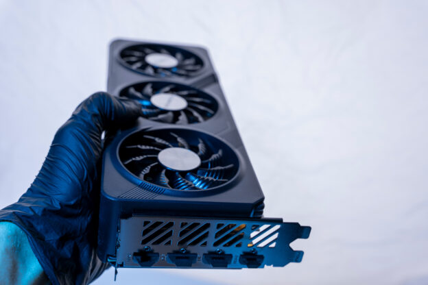 Mão com luva segura equipamento com microventiladores industriais utilizados para refrigeração de sistemas eletrônicos.