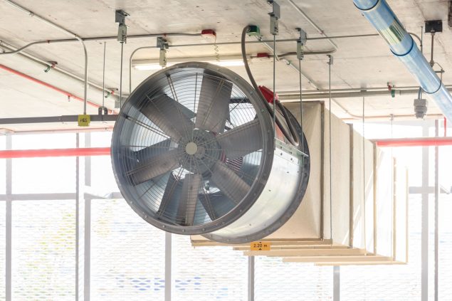 Exaustor industrial instalado em ambiente com sistema de ventilação e dutos